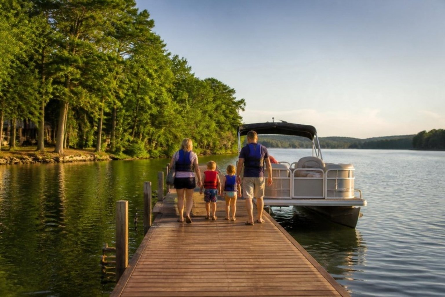 Family in life jackets on a dock at a Virginia lake in summer
